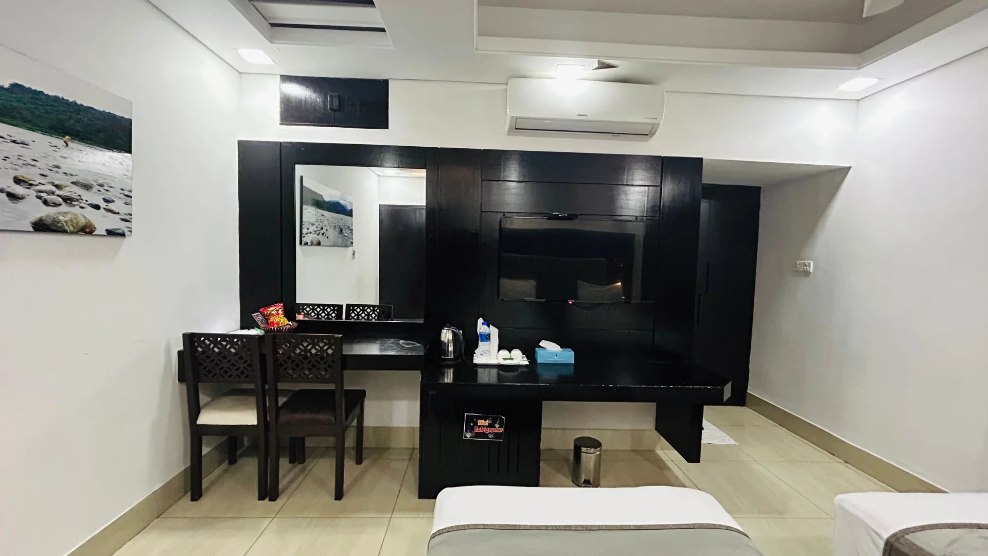 This Sky Lawn Hotel guest bathroom features a modern, accessible layout with a white toilet, vess...
