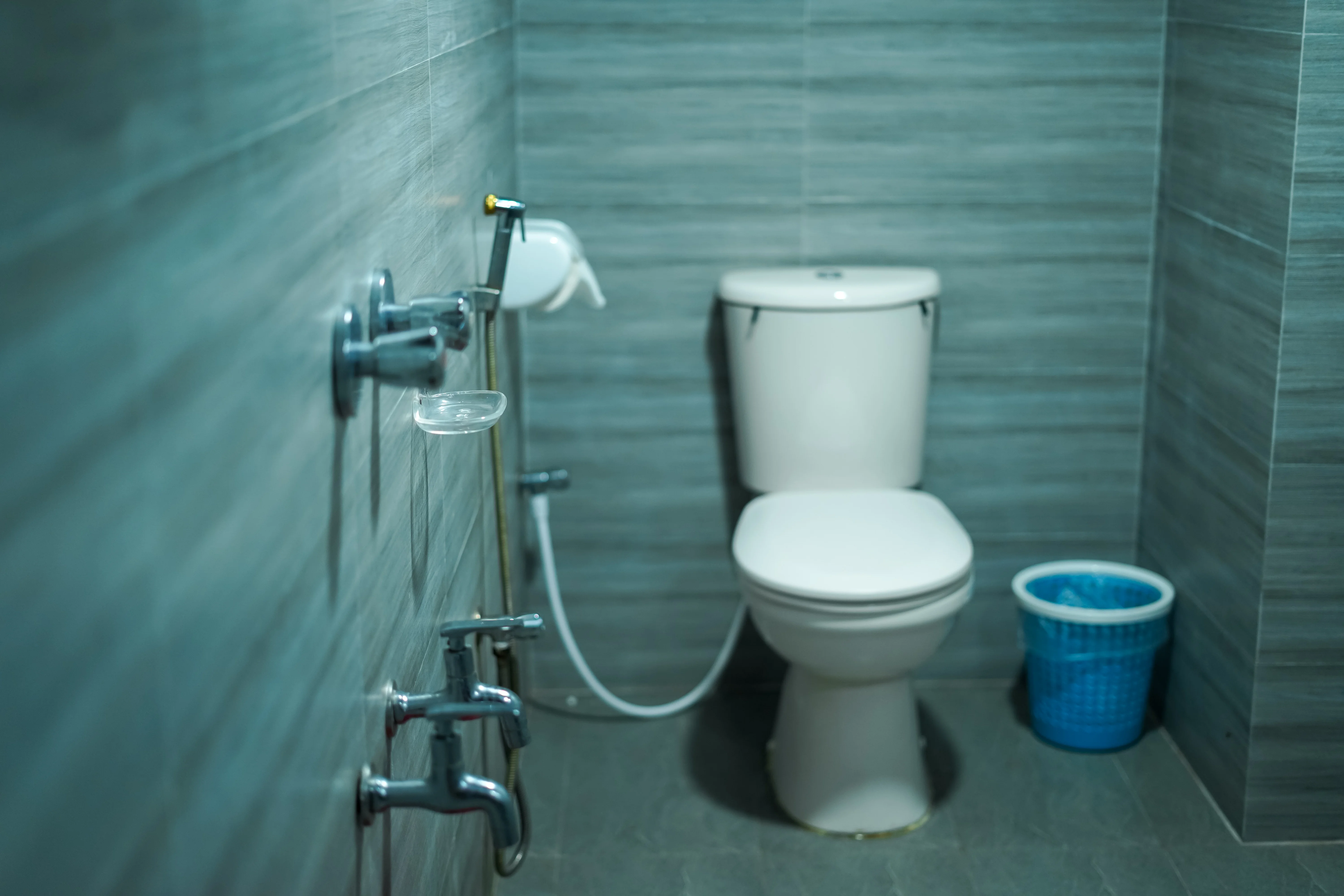 Sky Lawn Hotel's bathroom features a modern, accessible guest space with gray textured tile walls...
