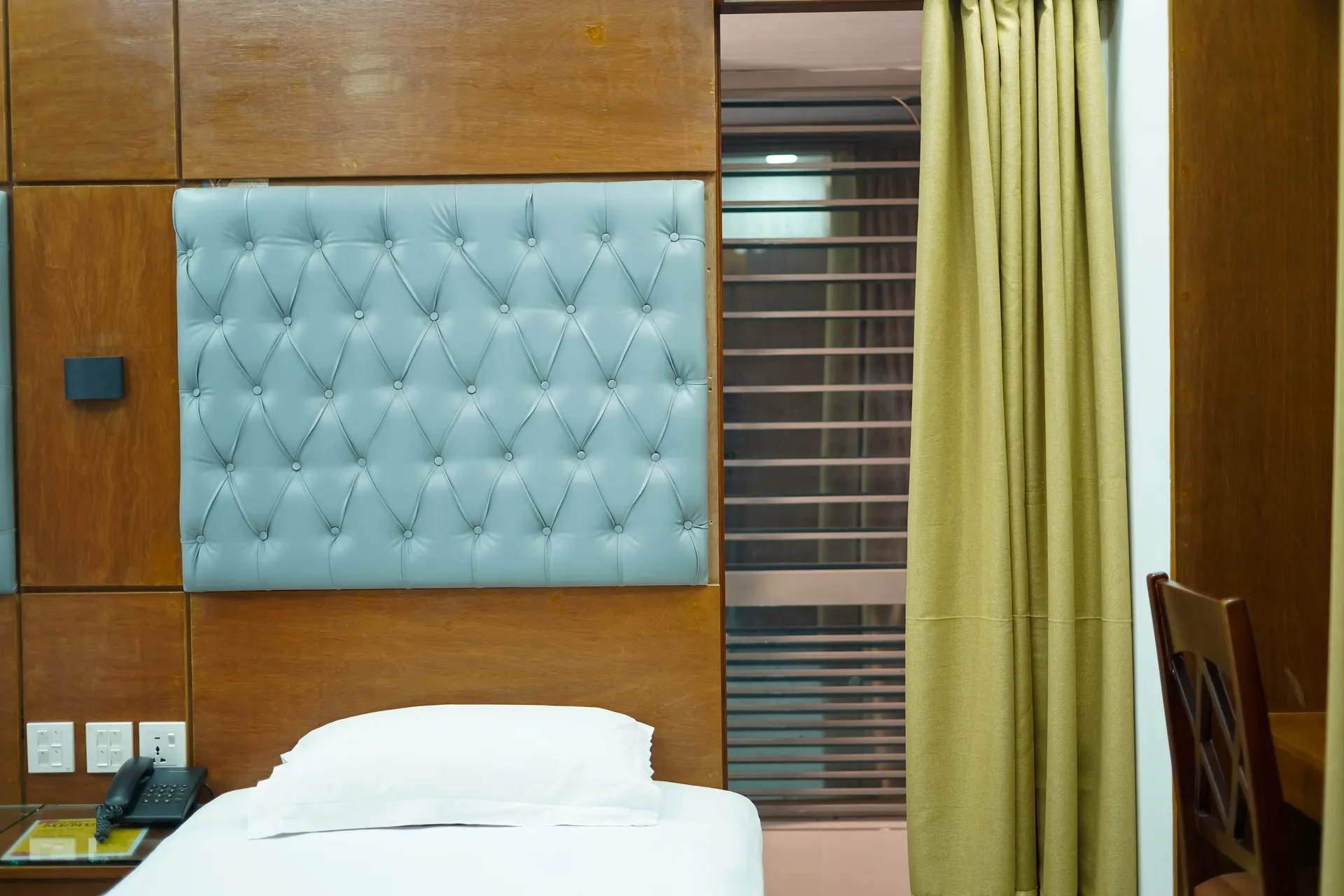 This Sky Lawn Hotel guest room features a cozy, warmly lit interior with rich wooden furniture, i...