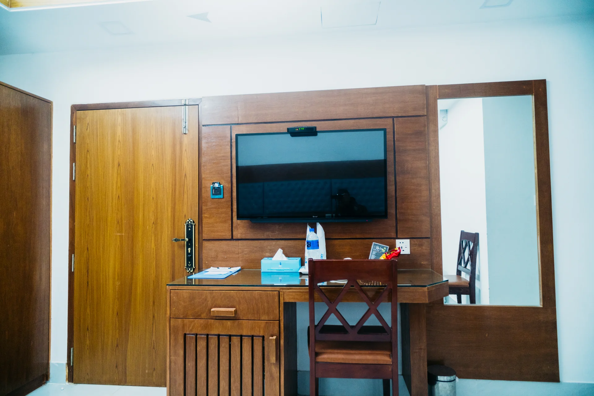 This Sky Lawn Hotel guest room features a cozy, warmly lit interior with rich wooden furniture, i...