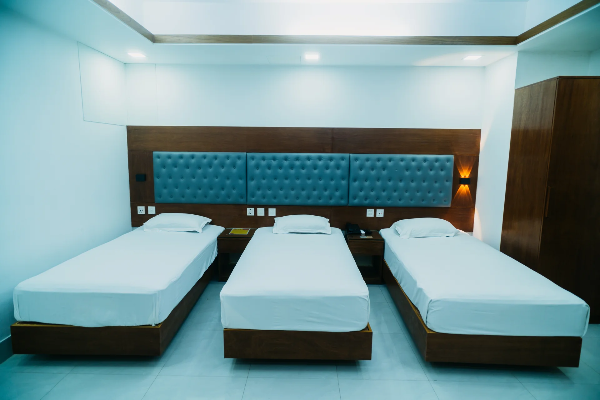 Sky Lawn Hotel’s three-single-bed room offers clean, modern accommodation with crisp white linens...