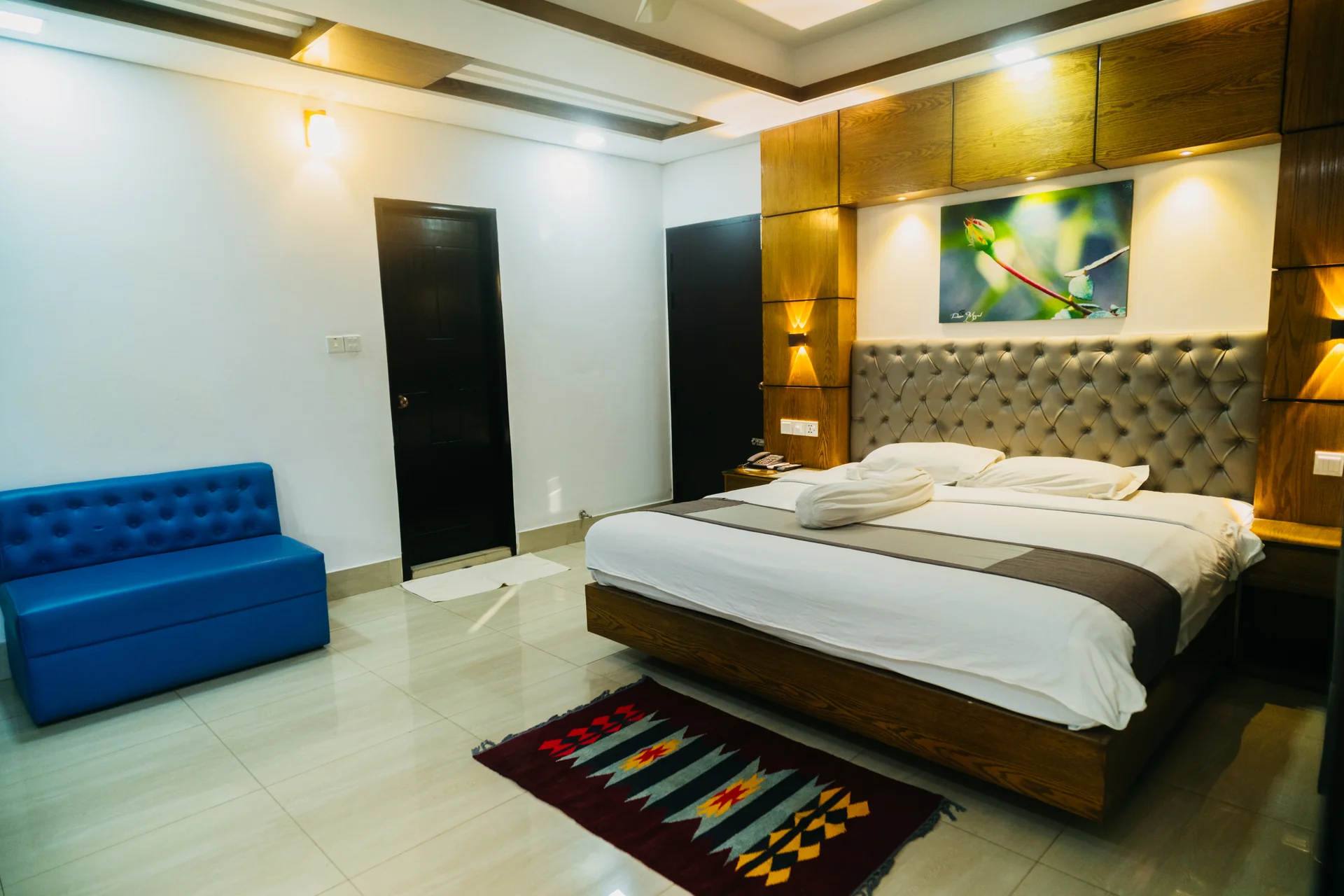 This Sky Lawn Hotel guest room features a cozy, warmly lit interior with rich wooden furniture, i...