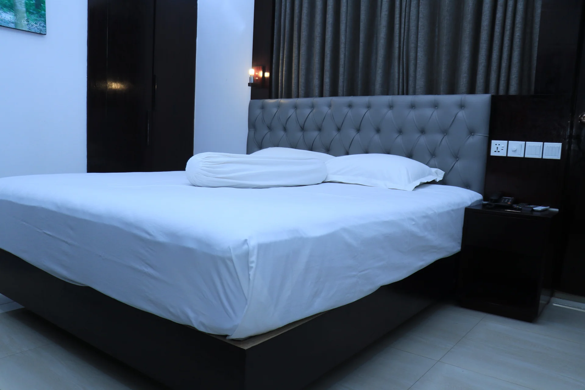 This Sky Lawn Hotel guest room features a cozy, warmly lit interior with rich wooden furniture, i...