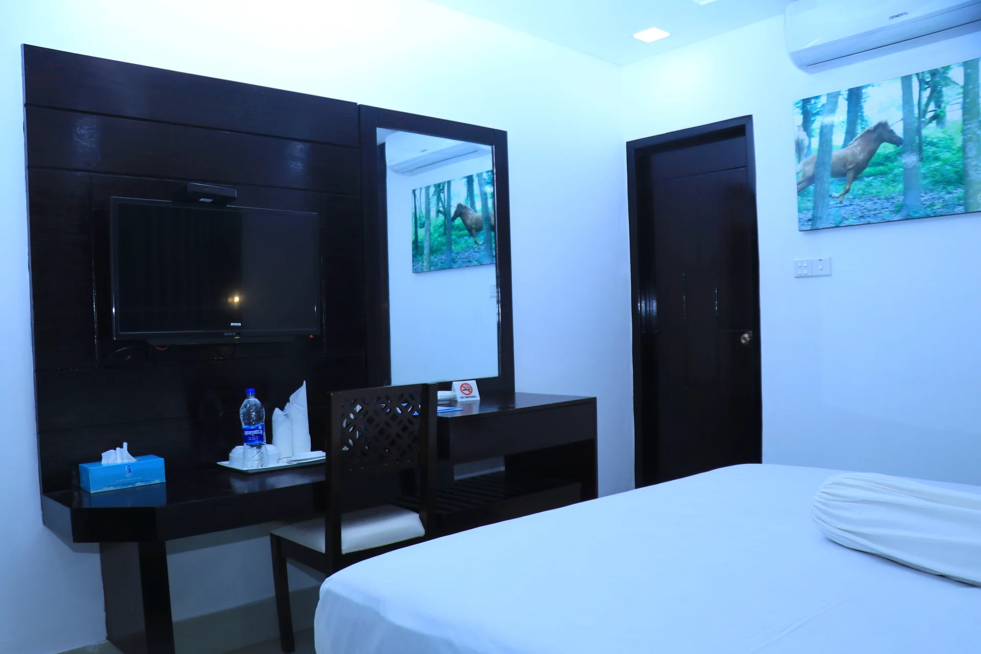 Sky Lawn Hotel's standard guest room features dark wood furniture (including a mounted TV, mirror...