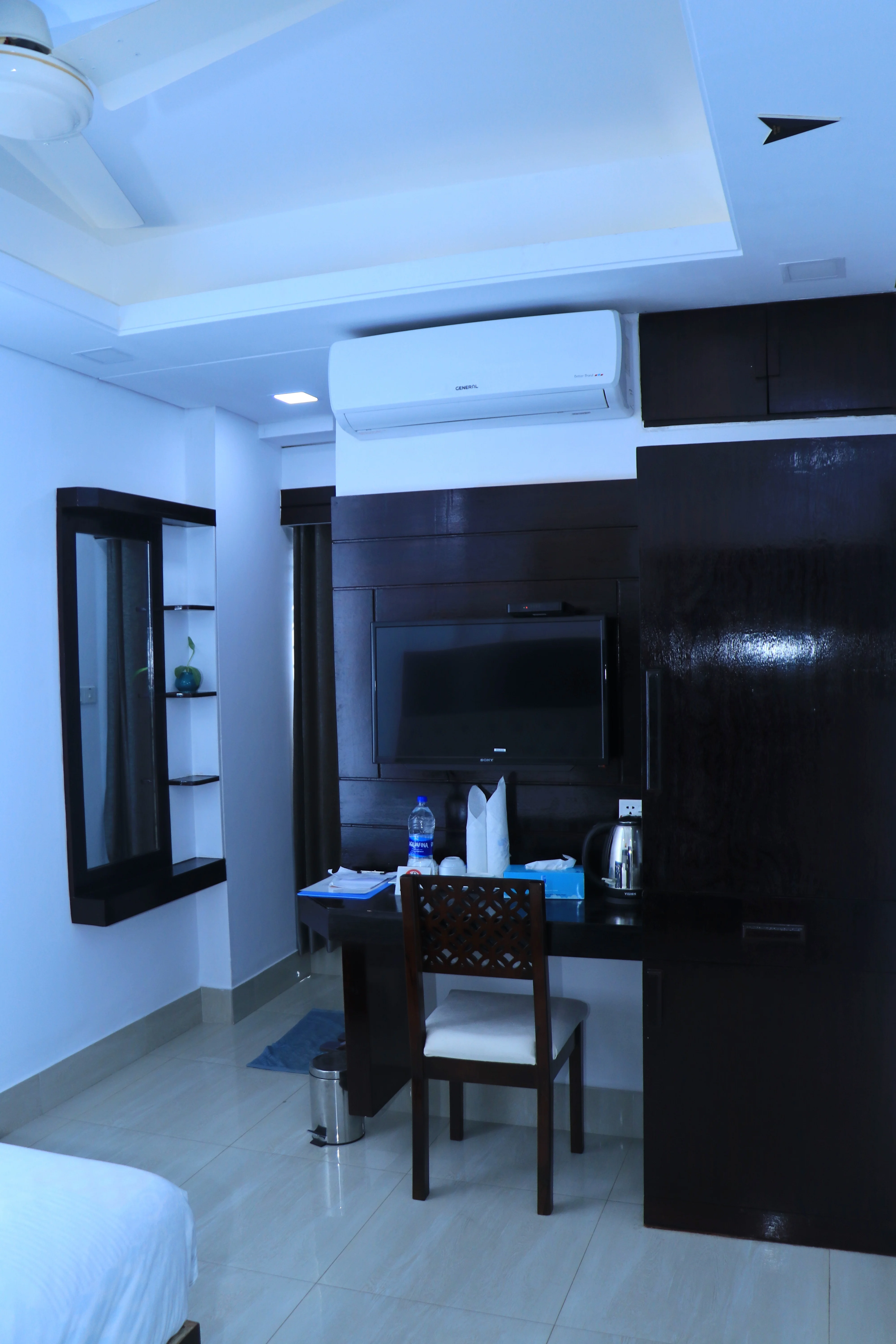 Sky Lawn Hotel guest room features a modern, elegantly designed space with a king-sized bed, tuft...