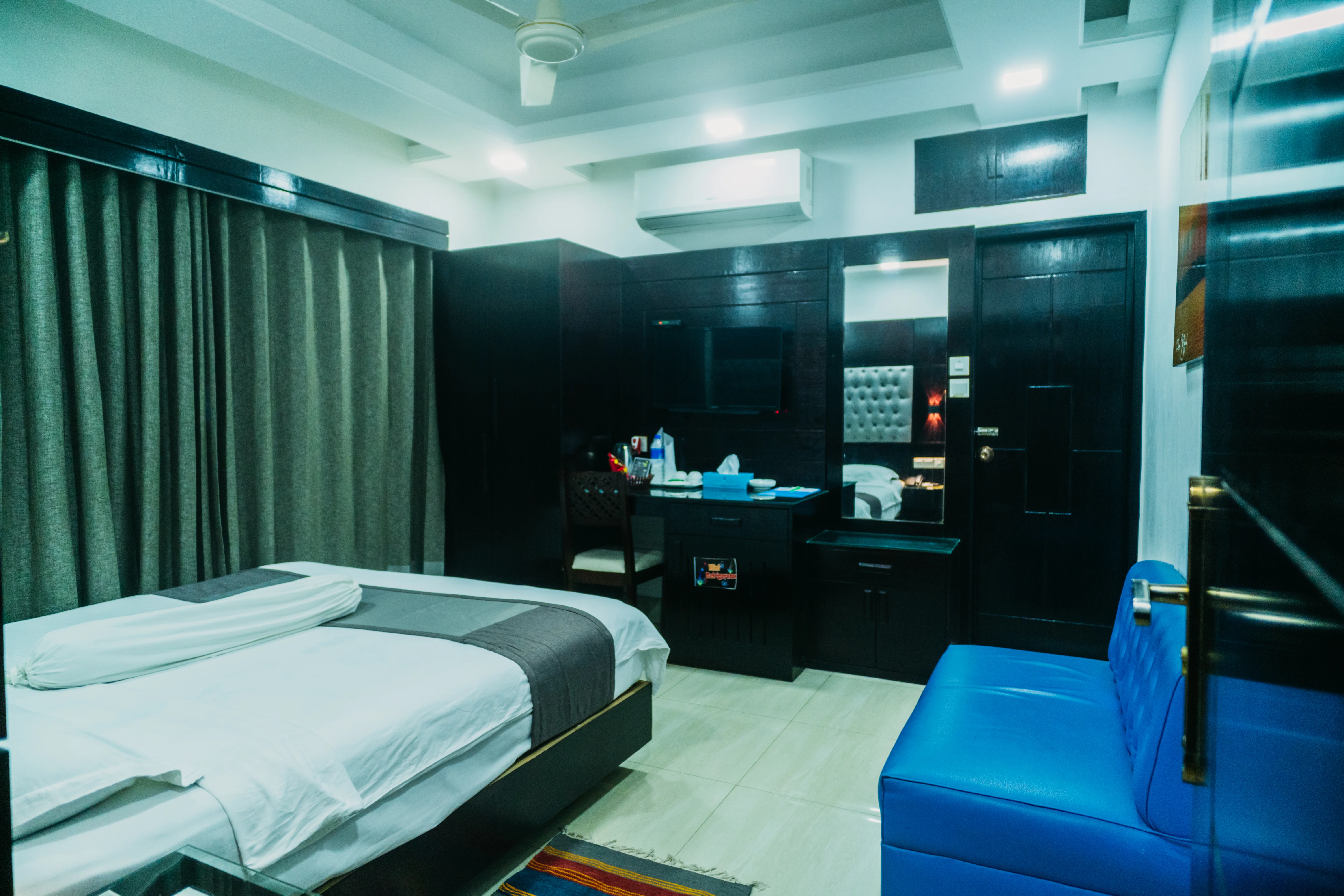 This Sky Lawn Hotel guest room features a cozy, warmly lit interior with rich wooden furniture, i...