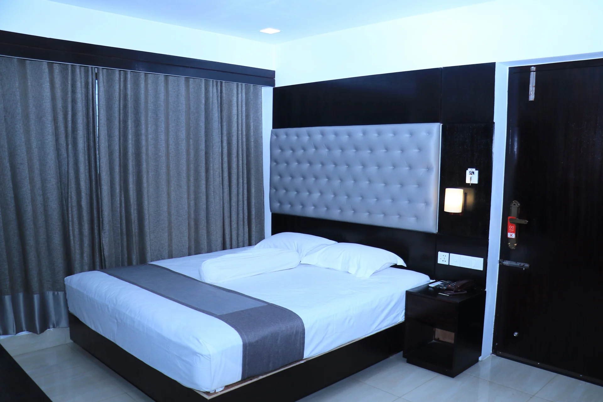 This Sky Lawn Hotel guest room features a cozy, warmly lit interior with rich wooden furniture, i...