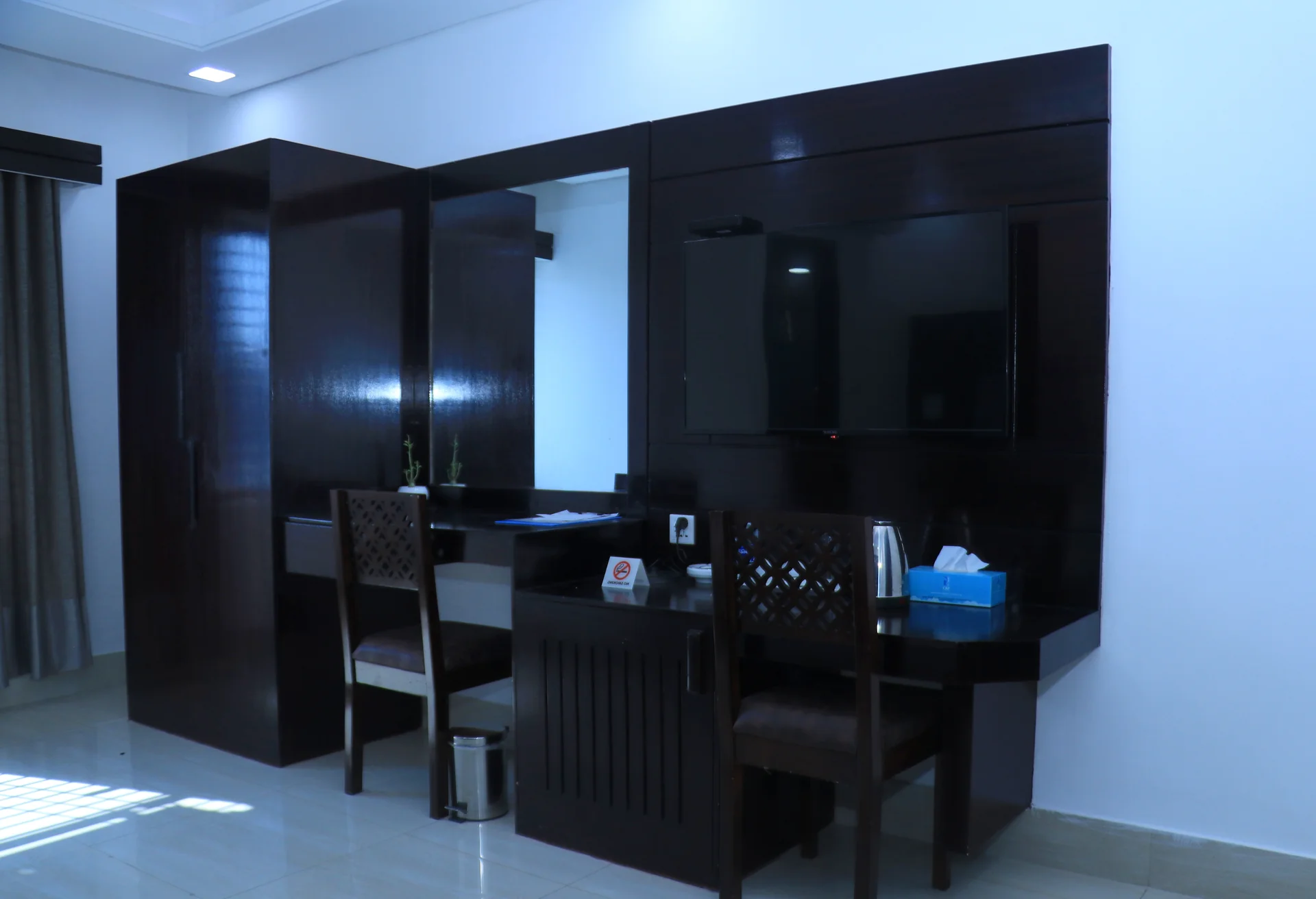 Sky Lawn Hotel guest room features a modern, elegantly designed space with a king-sized bed, tuft...