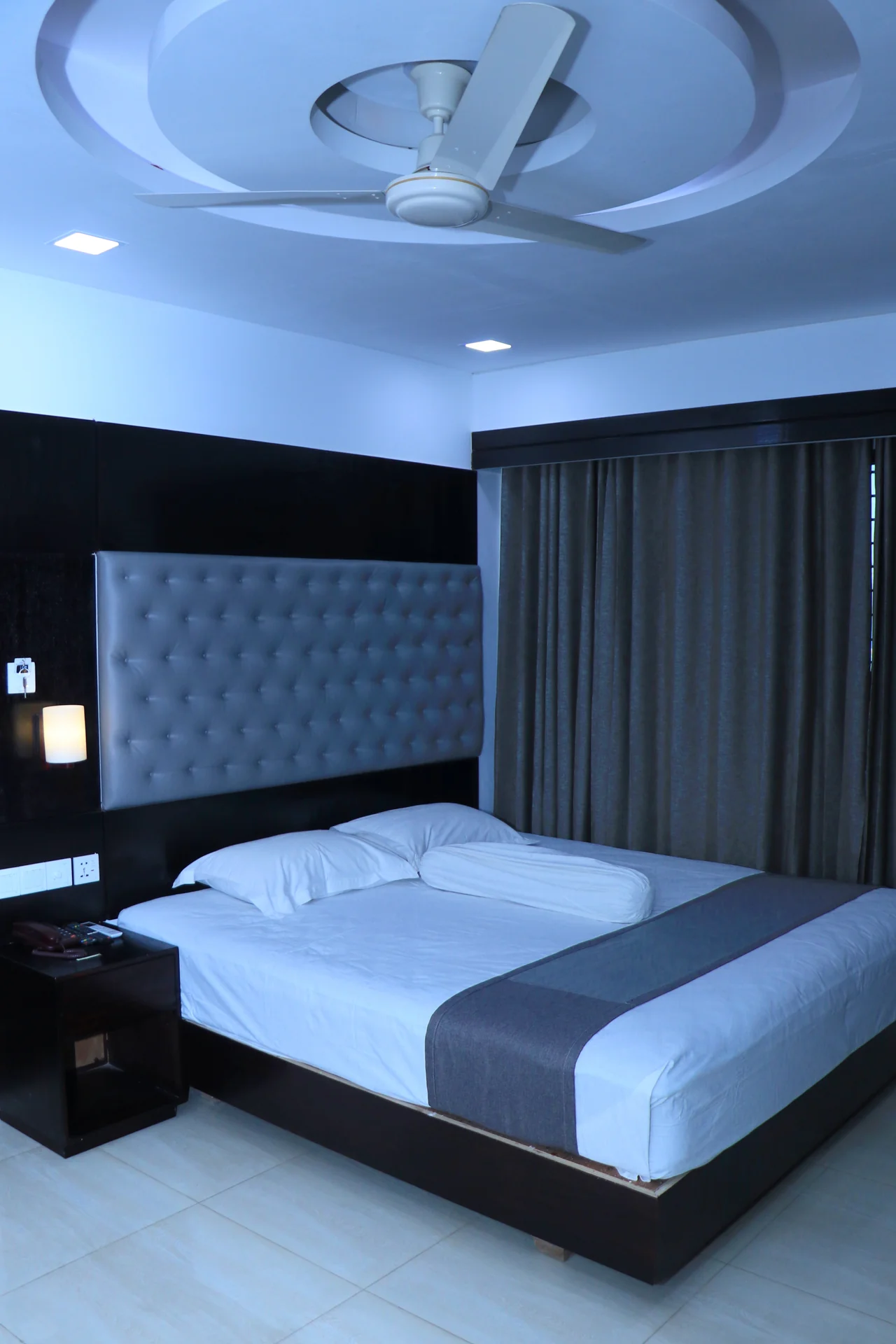 This modern guest room at Sky Lawn Hotel features a plush king-sized bed with crisp white linens ...