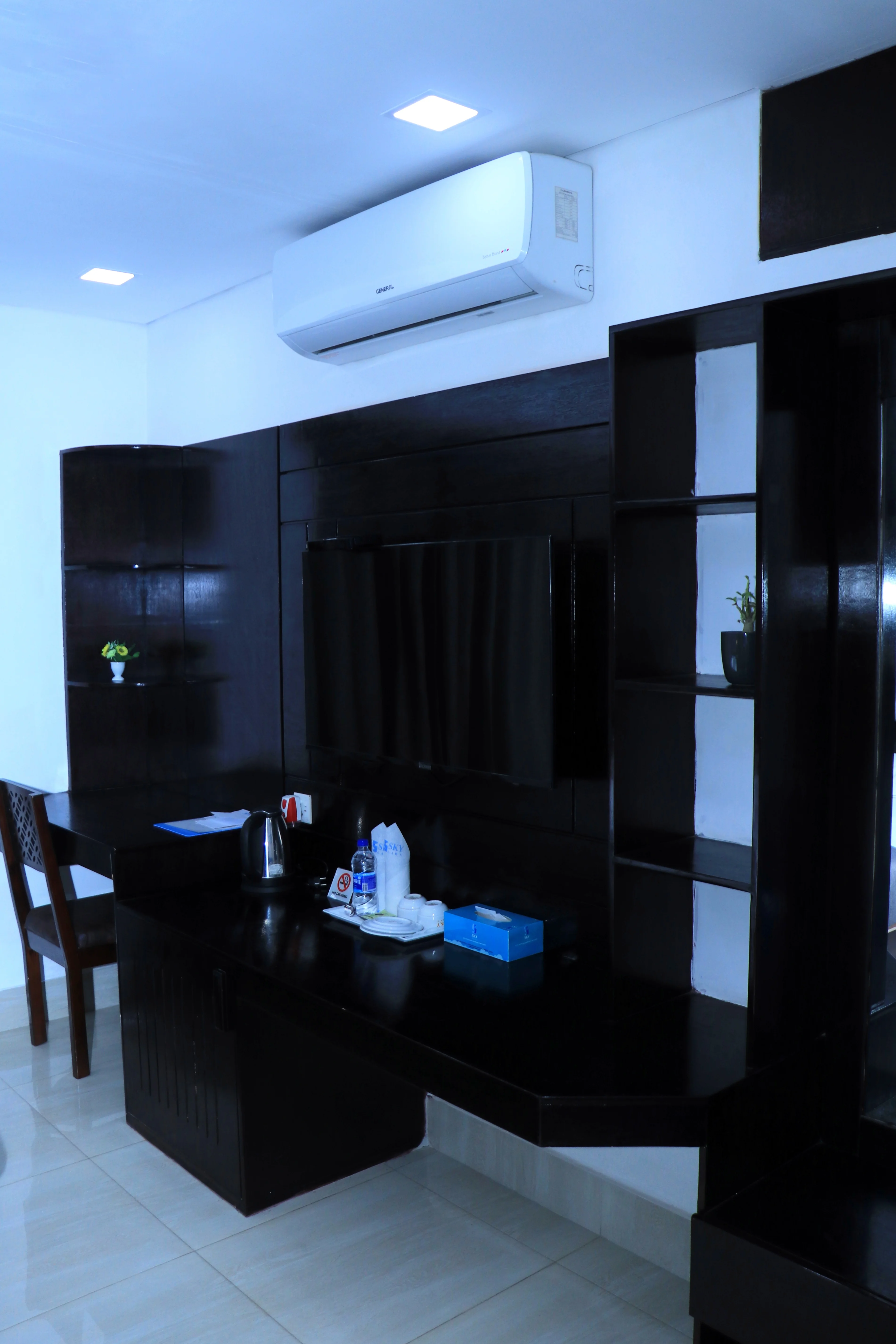 This Sky Lawn Hotel guest room features a cozy, warmly lit interior with rich wooden furniture, i...