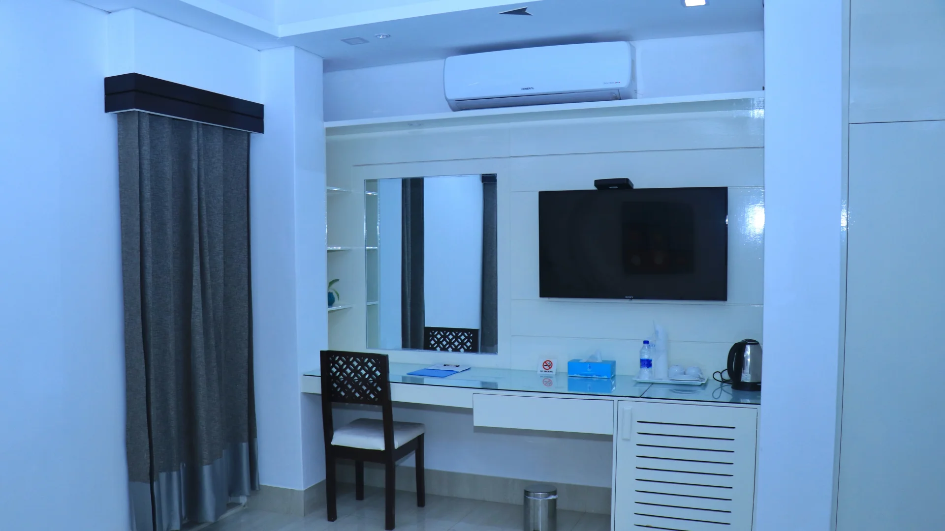 Sky Lawn Hotel guest room features a modern, elegantly designed space with a king-sized bed, tuft...